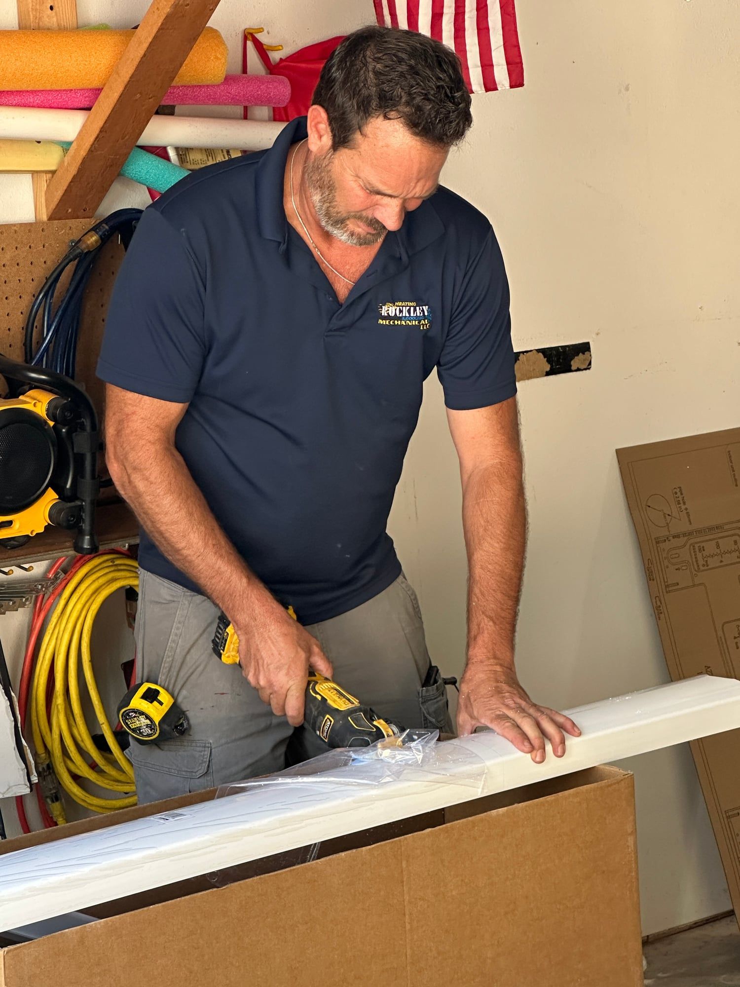 A Rockley Mechanical technician in a company polo cutting trim with an oscillating tool
